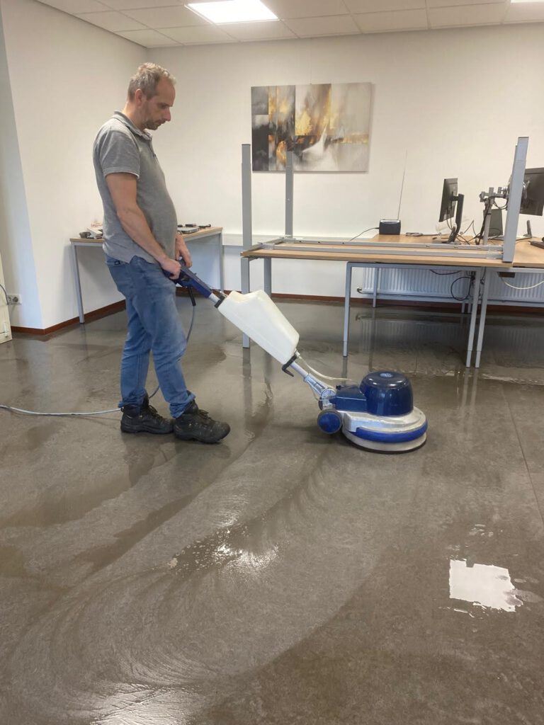Medewerker reinigt een Marmoleumvloer met een eenschijfsmachine in een kantoor in Ede